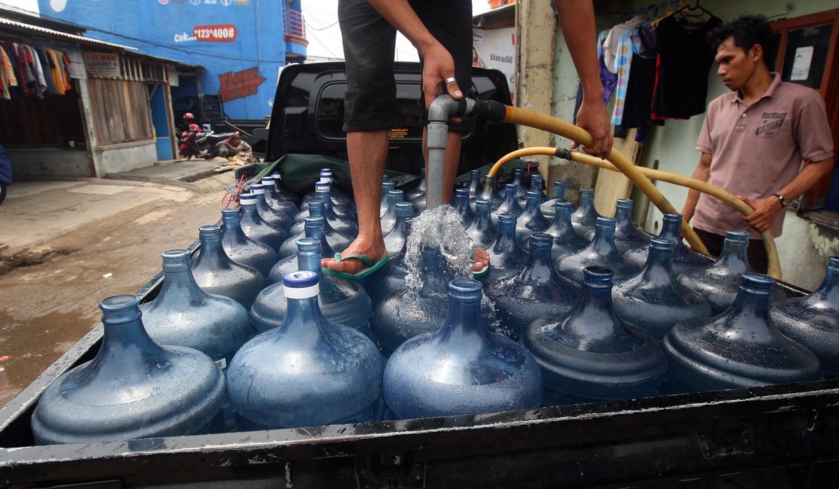Pedagang membersihkan galon air minum dalam kemasan (AMDK).