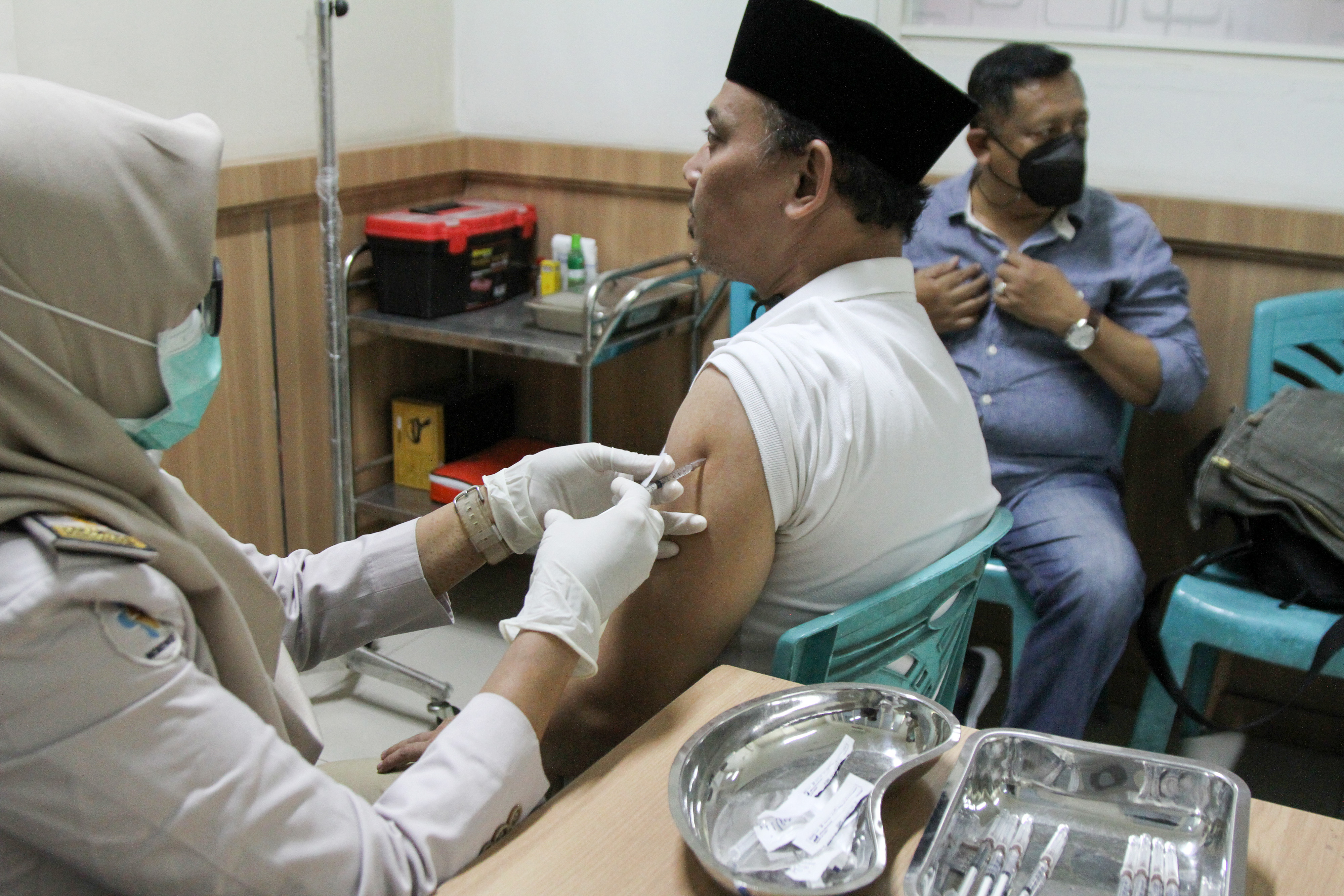 Petugas kesehatan menyuntikkan vaksin meningitis kepada calon jamaah umrah di Sidoarjo, Jawa Timur. 