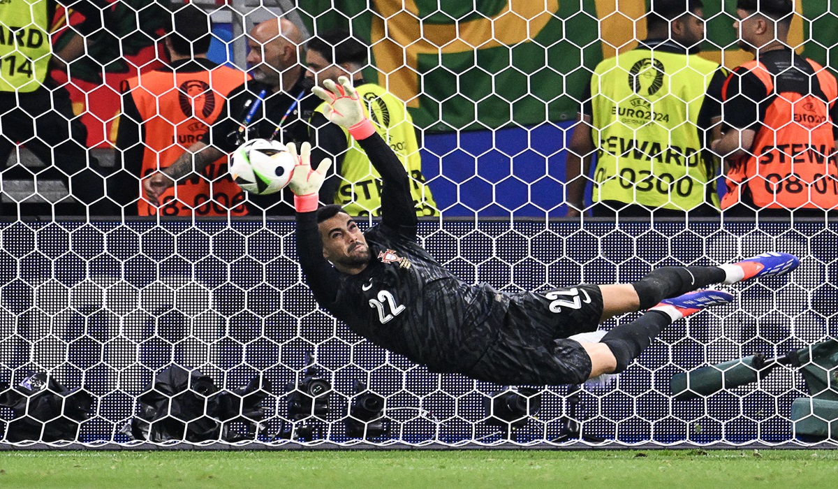 Penjaga gawang timnas Portugal Diogo Costa menahan eksekusi penalti pemain Slovenia di laga 16 besar Euro 2024.