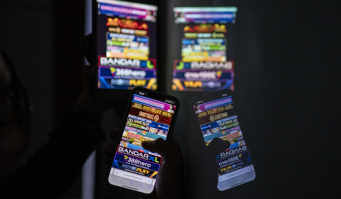 Warga melihat iklan judi online melalui gawainya 