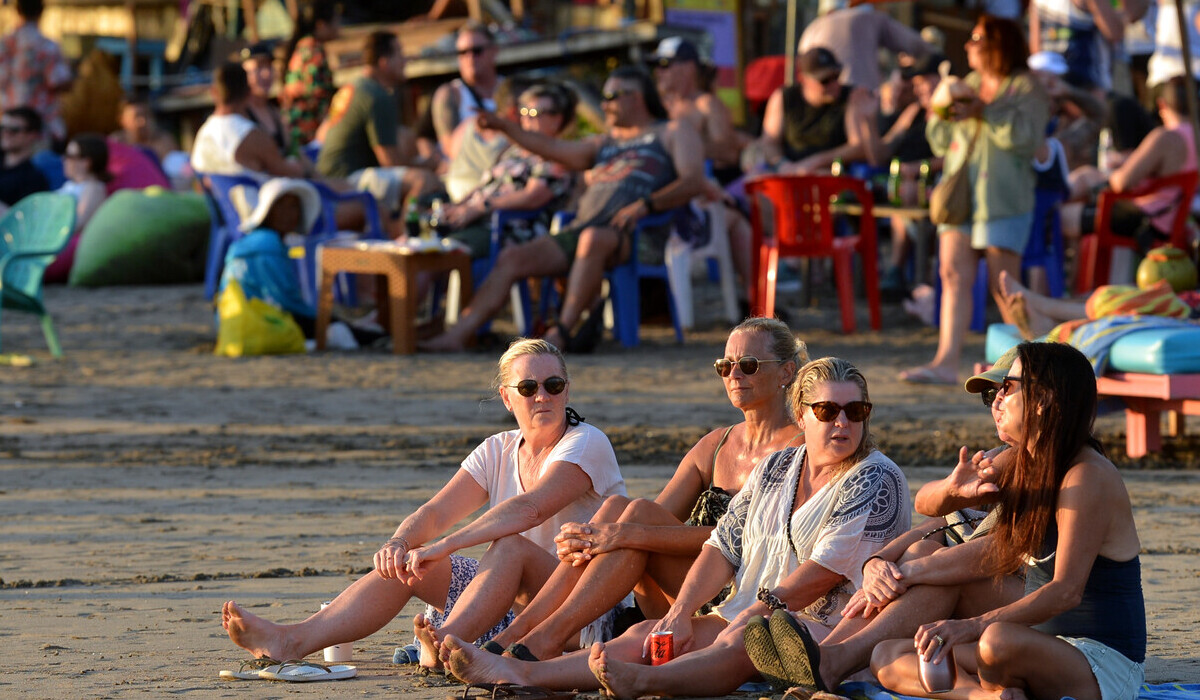 WNA atau wisatawan mancanegara (wisman) duduk di tepi Pantai Double Six di kawasan Seminyak, Badung, Bali.
