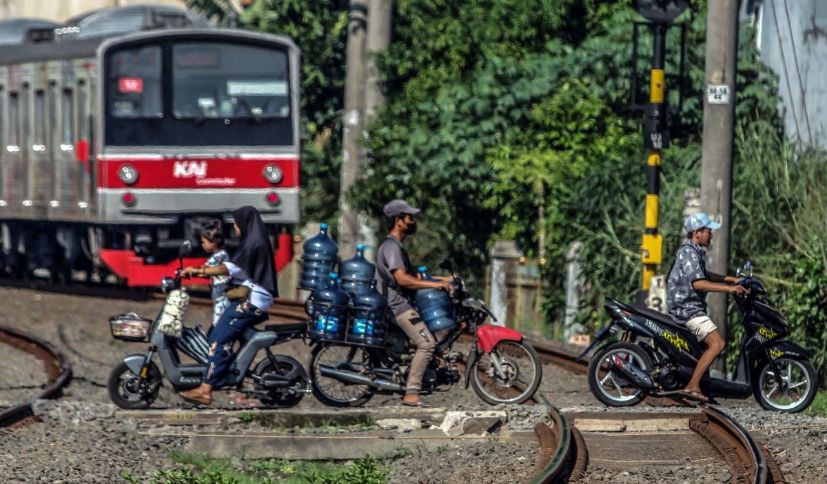 Pengendara sepeda motor melintasi perlintasan sebidang kereta api kawasan Bojonggede, Kabupaten Bogor, Jawa Barat, Senin (8/7/2024).