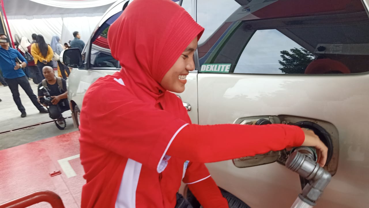 Petugas mengisi bensin ke kendaraan. 