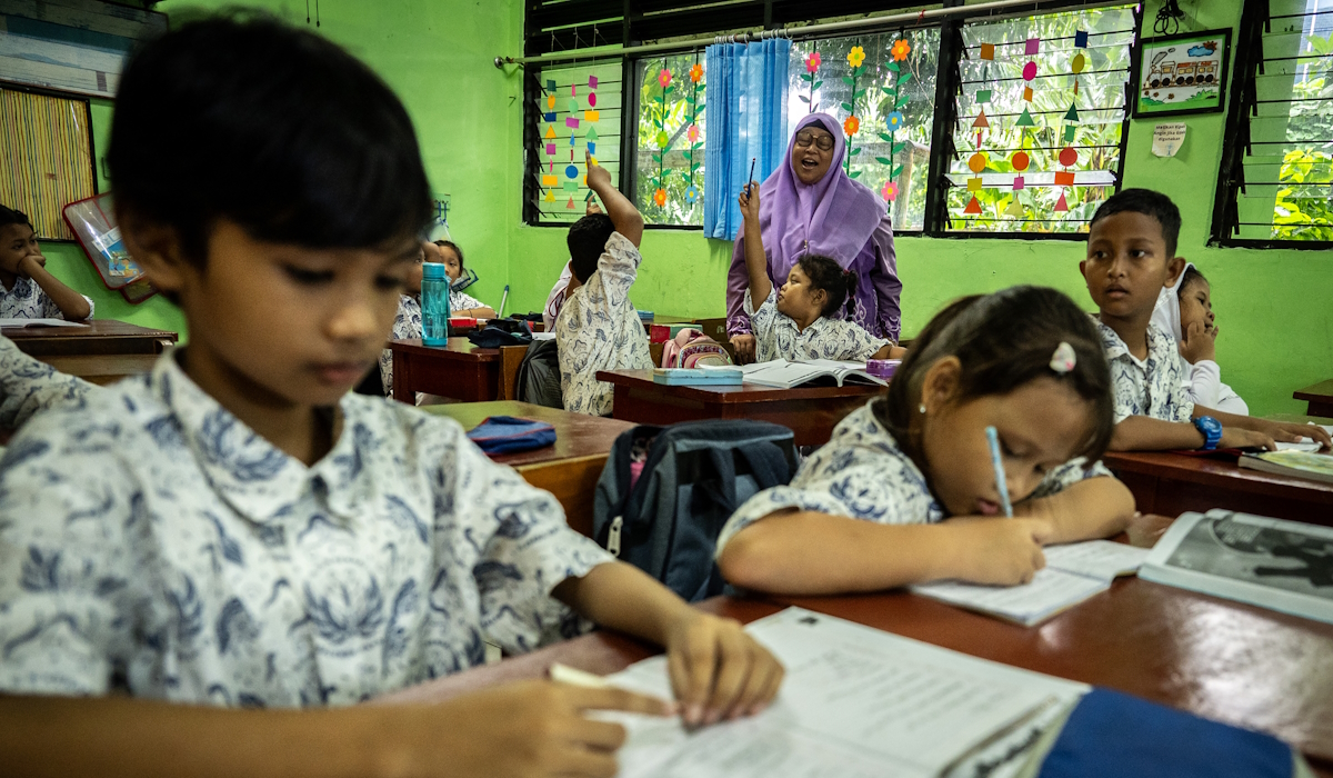 Seorang guru memberikan mata pelajaran kepada siswanya 