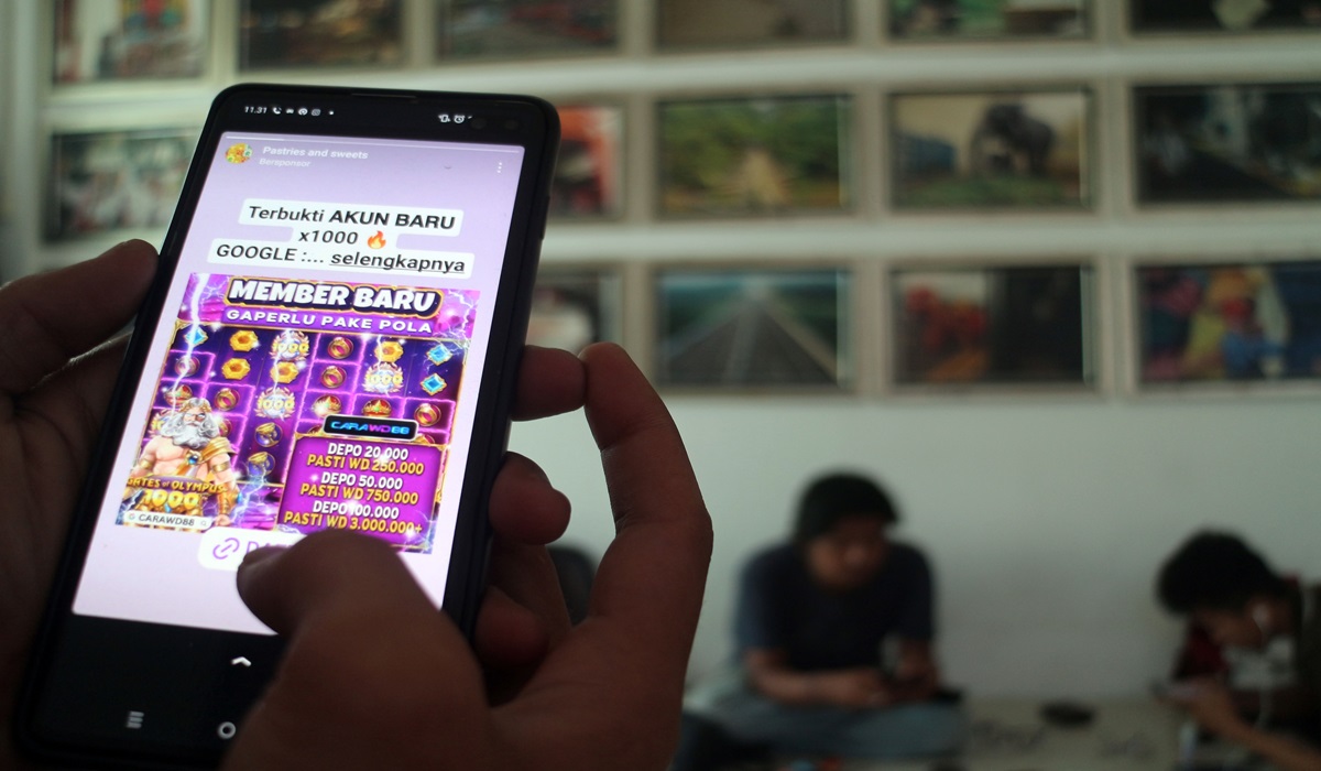 Warga melihat iklan judi online melalui gawainya di Bogor, Jawa Barat.