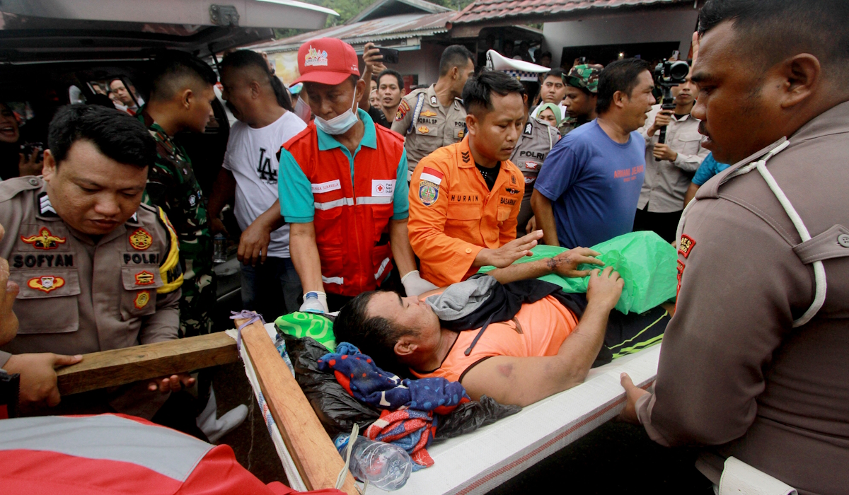 Petugas membawa penambang yang menjadi korban selamat dari longsor menuju mobil ambulans di Desa Tulabolo, Suwawa Timur, 
