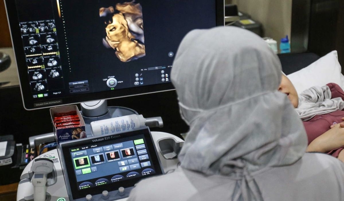 Dokter spesialis kebidanan dan kandungan memeriksa janin ibu hamil dengan peralatan Ultrasonografi (USG) di RSIA Tambak, Jakarta.
