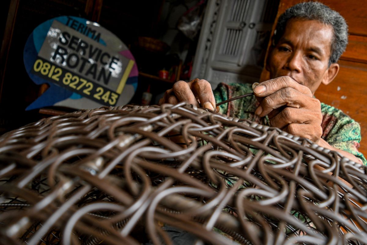  Perajin menyelesaikan pembuatan kerajinan ayunan rotan.