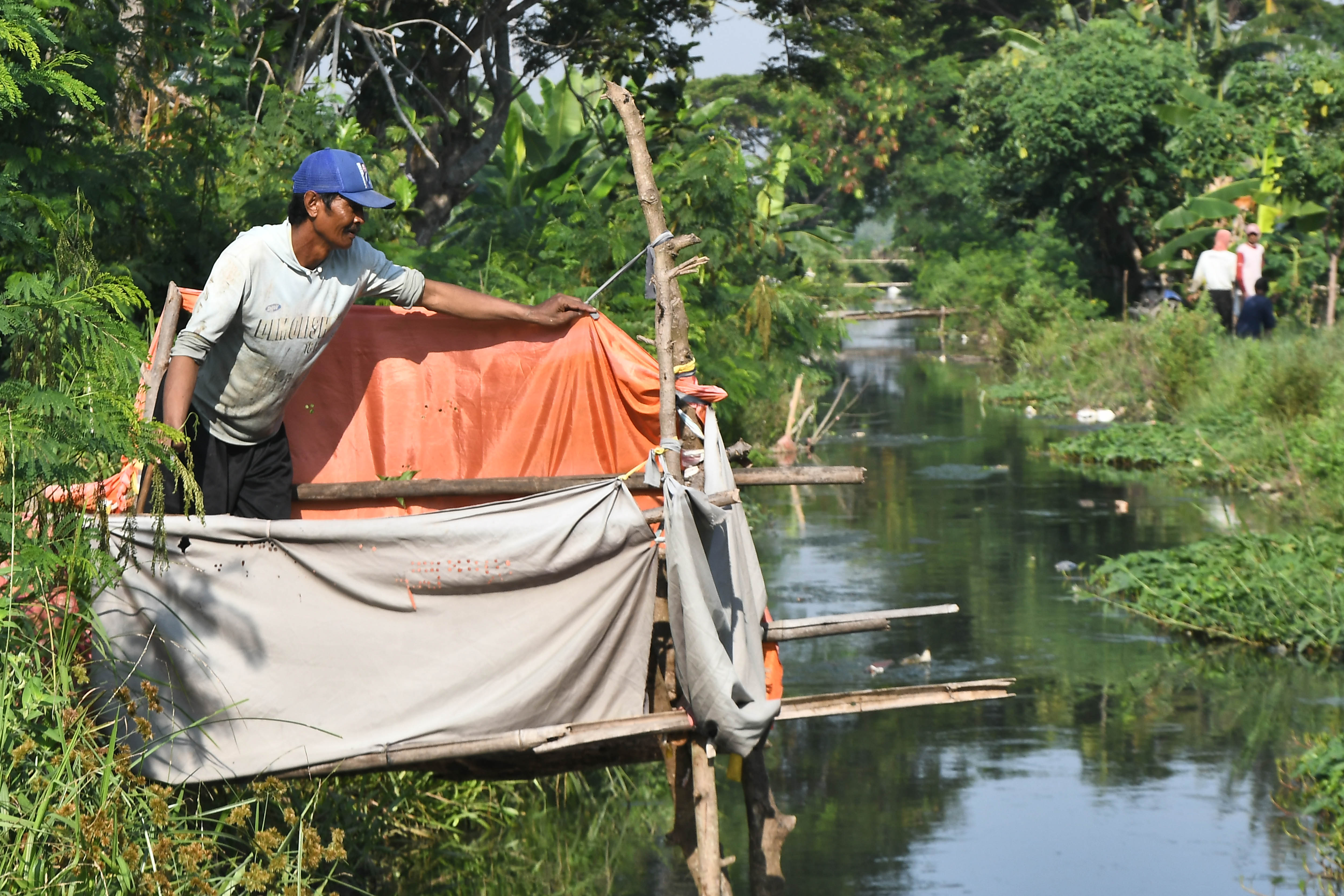 Warga menggunakan jamban di aliran kali di Desa Sukawijaya, Tambelang, Kabupaten Bekasi, Jawa Barat, Rabu (20/12/2023)