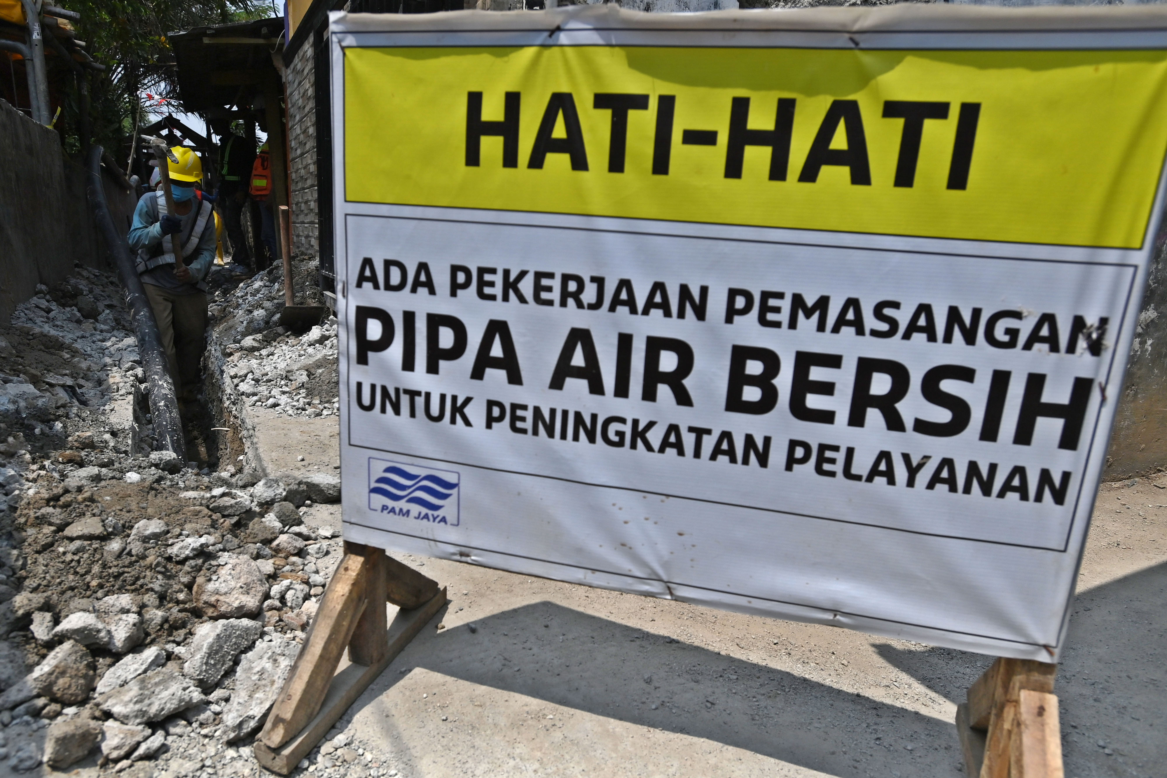 Pekerja Perumda Perusahaan Air Minum (PAM) Jaya menggali tanah untuk jaringan pipa air bersih di lingkungan RW 01, Kamal Muara, Jakarta