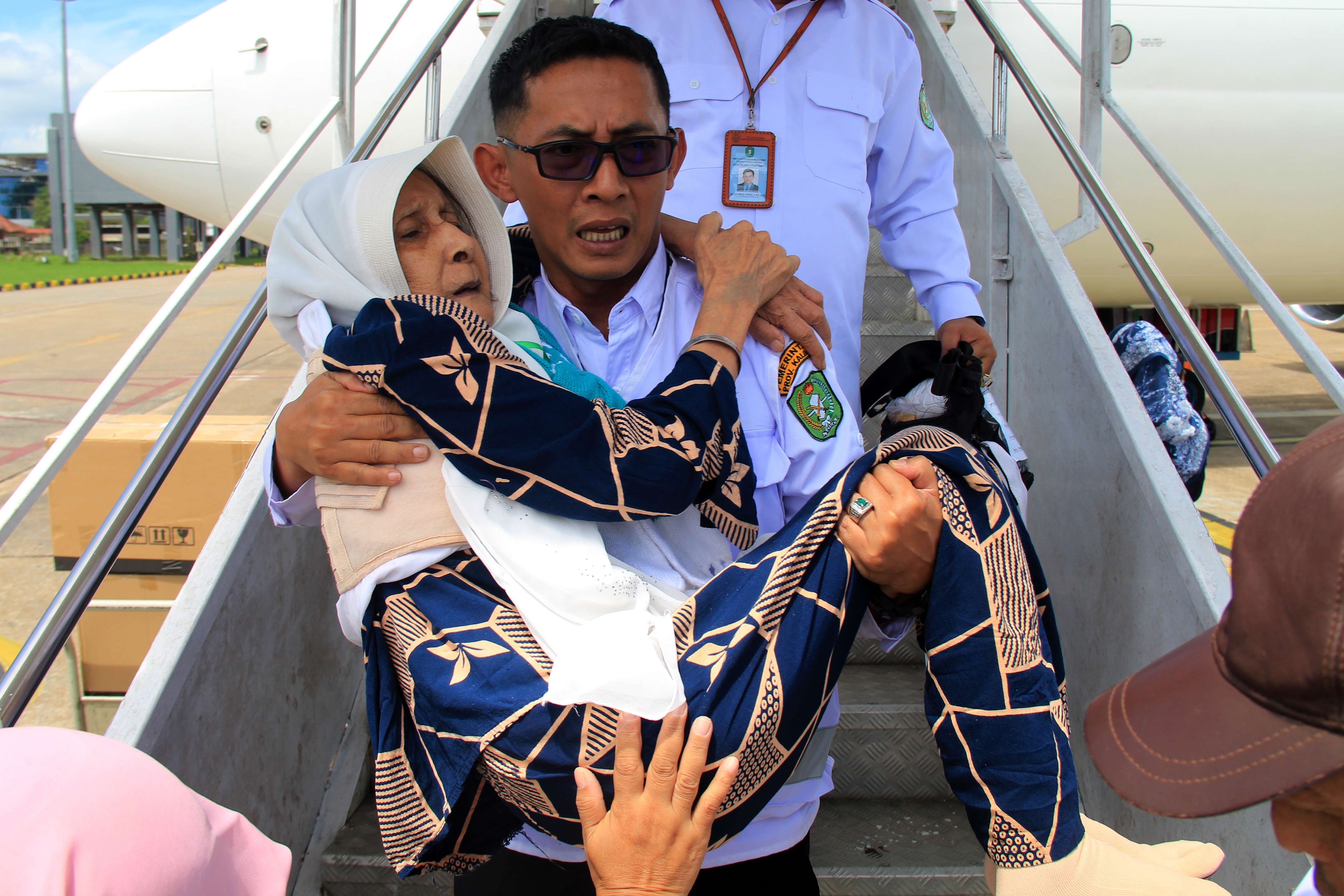 Petugas menggendong jemaah haji lansia asal Kalimantan Barat saat tiba di Bandara Supadio, Kabupaten Kubu Raya, Kalimantan, Rabu (10/7/2024)