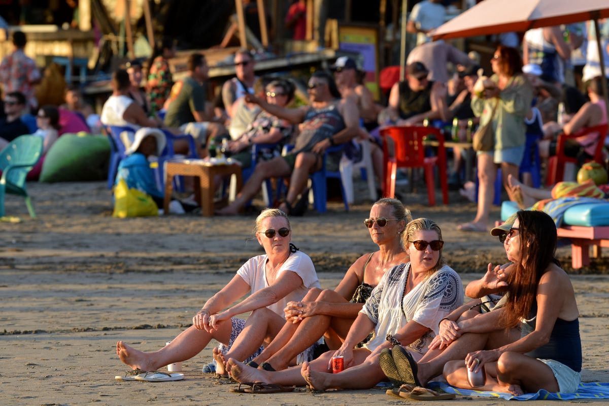 Wisatawan mancanegara duduk di tepi pantai di kawasan Seminyak, Badung, Bali.