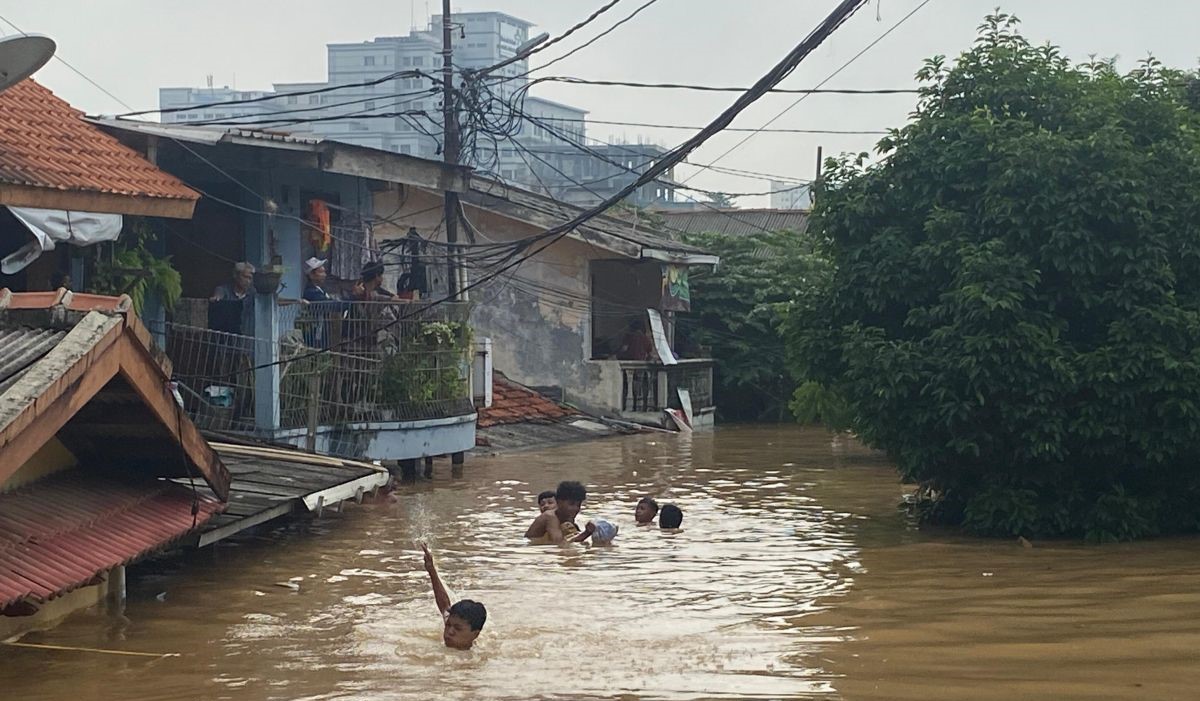 Anak -anak berenang di lingkungan banjir 3 meter di Pancoran