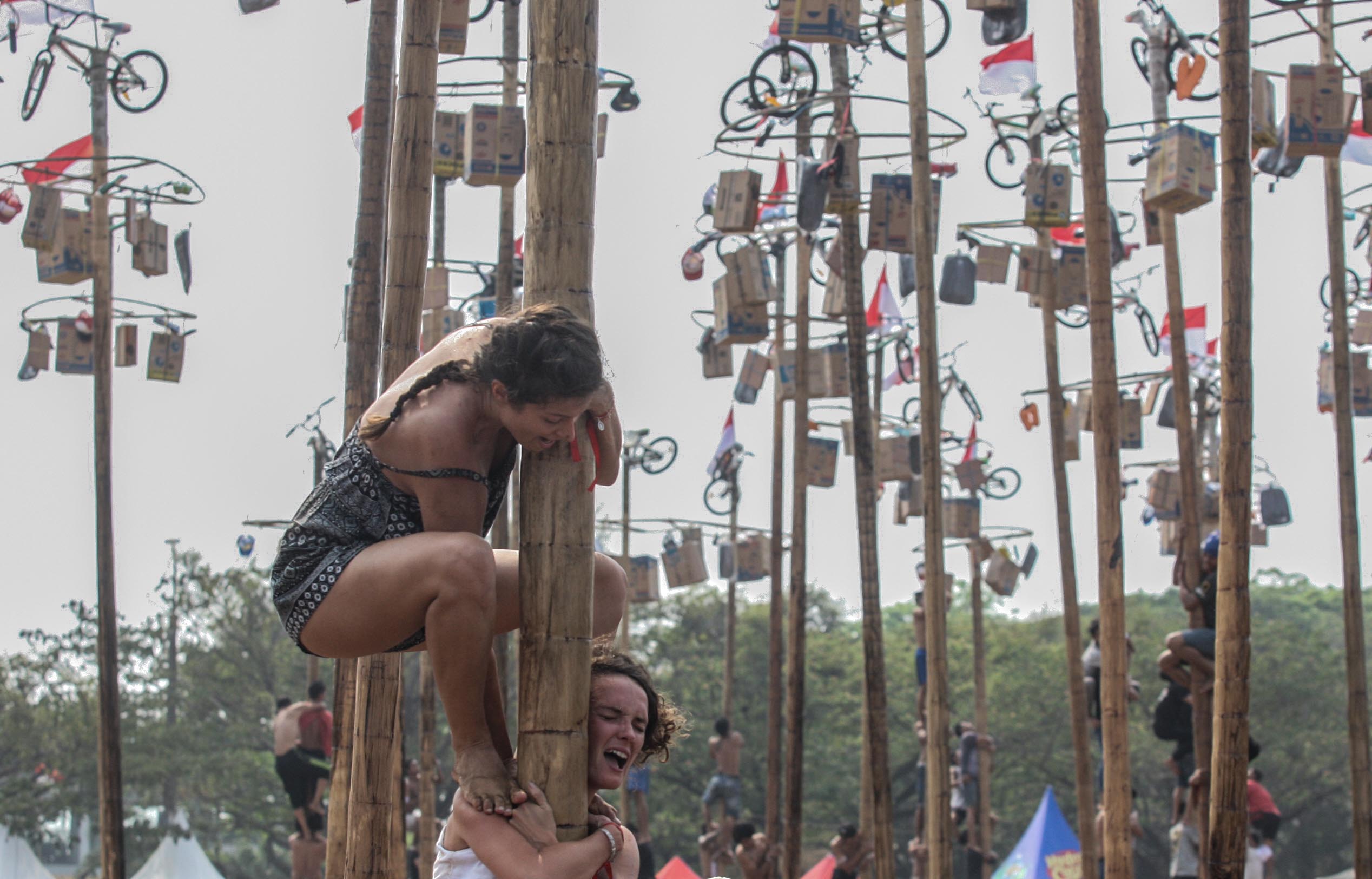 WNA Mengikuti Lomba Panjat Pinang Kolosal di Ancol