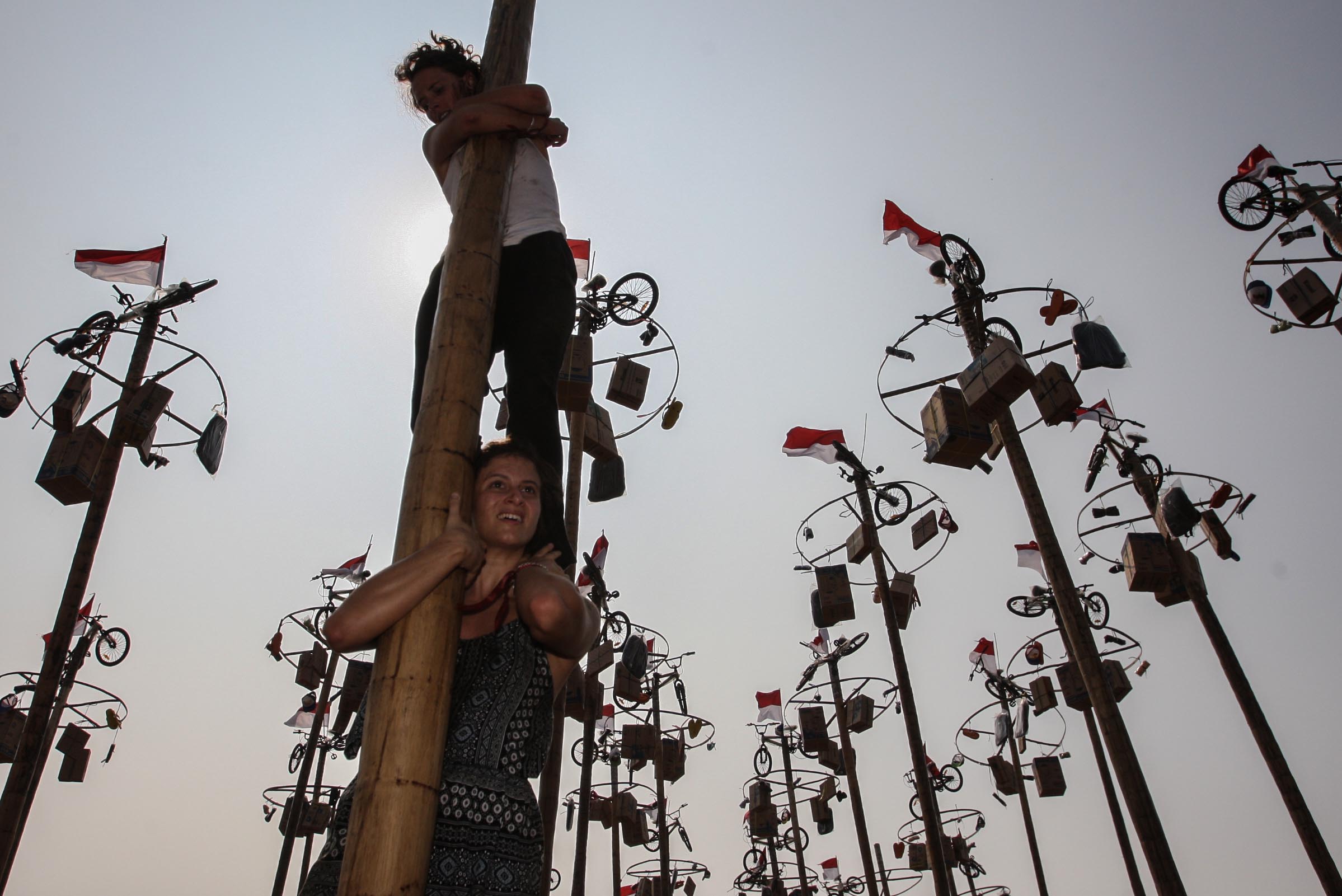 WNA Mengikuti Lomba Panjat Pinang Kolosal di Ancol