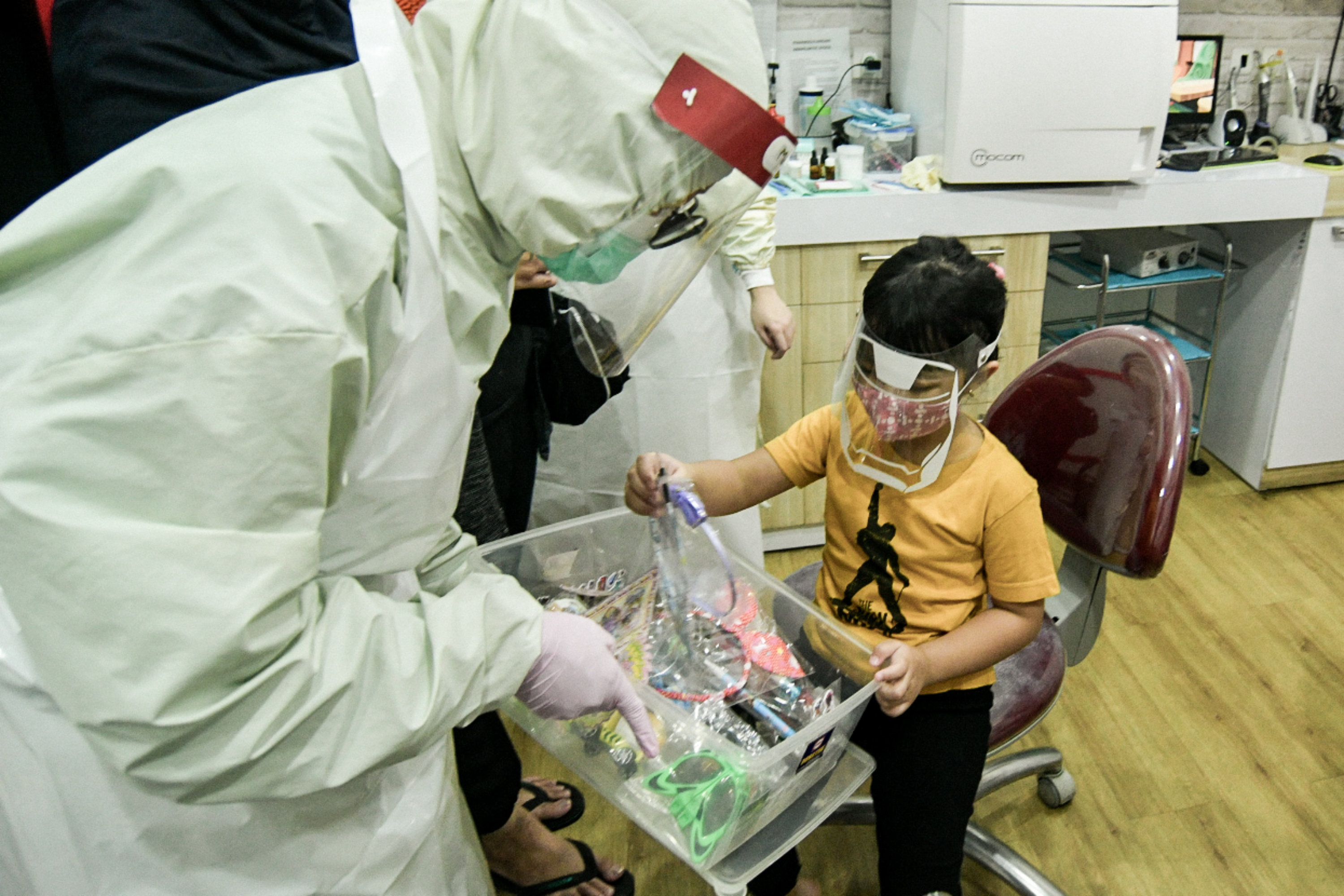 Dokter Periksa Gigi Anak Mengenakan APD Lengkap