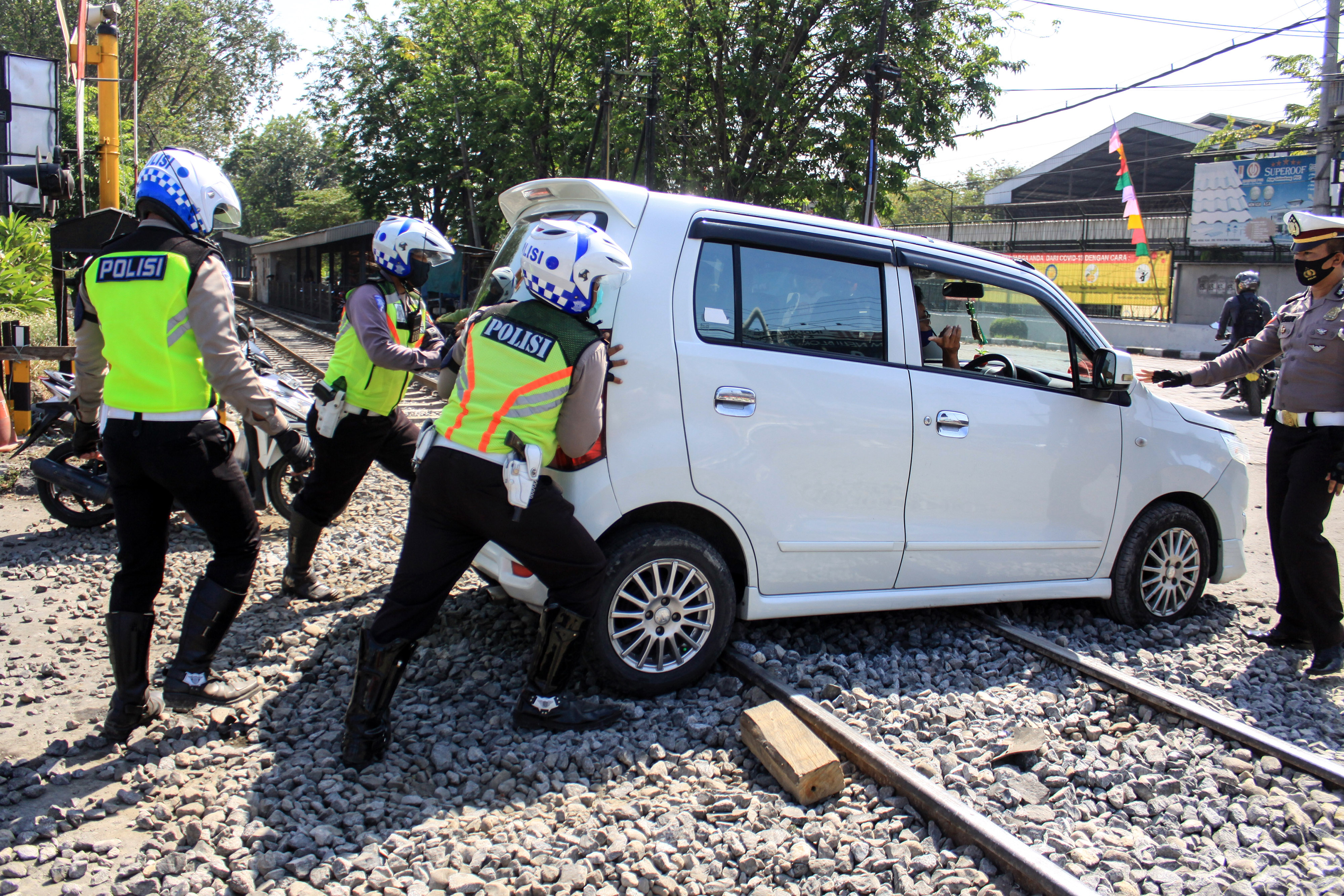 Polantas Bantu Pengendara Melintas di Jalur Kereta Api