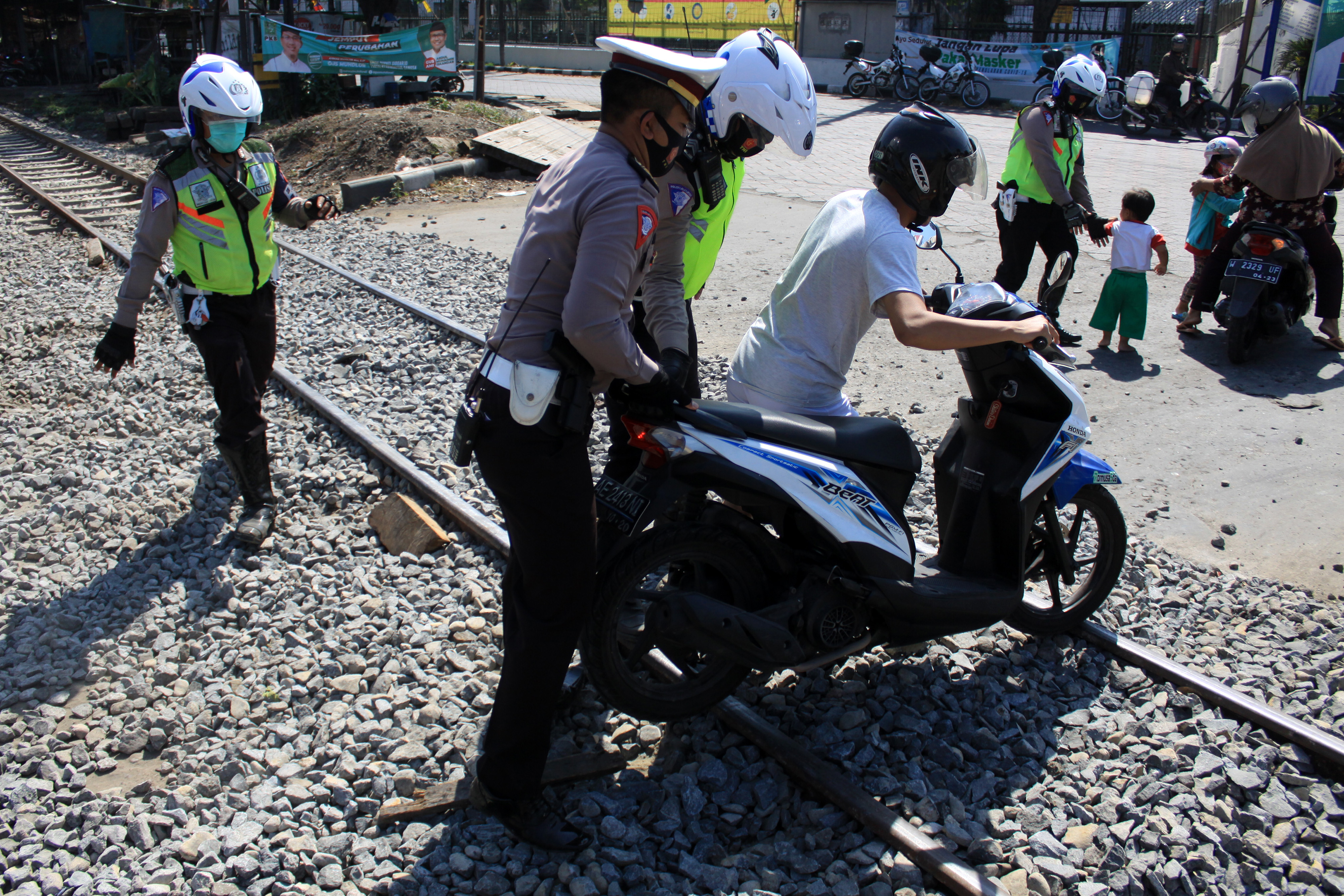 Polantas Bantu Pengendara Melintas di Jalur Kereta Api