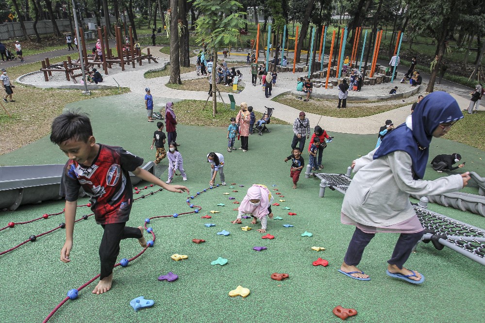 Warga Memanfaatkan Masa Libur dengan Bermain dan Berolahraga di Taman Terbuka