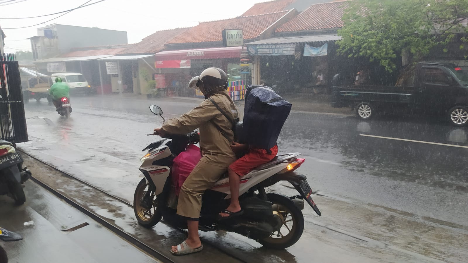 Gunakan Tas Belanja Gantikan Jas Hujan 