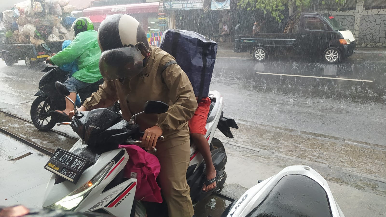 Gunakan Tas Belanja Gantikan Jas Hujan 